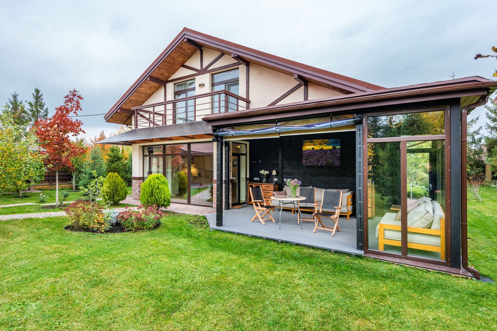 Maison avec terrasse couverte ouverte sur un jardin paysager