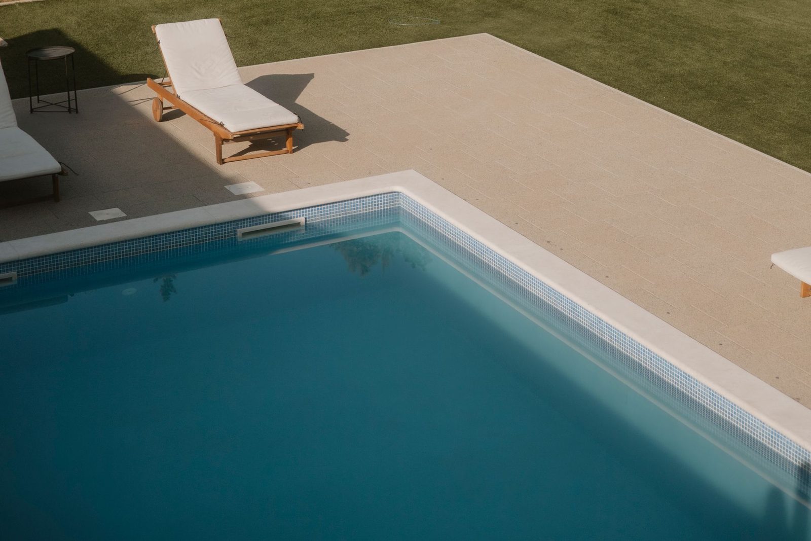 Piscine bordée d’une plage minérale et d’une pelouse